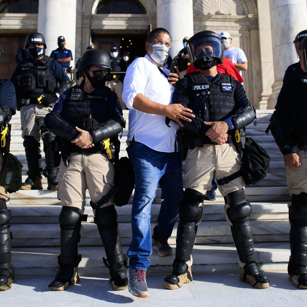 Tatito Hernández cruza la línea de policías durante manifestación por el contrato de LUMA, en el Capitolio.