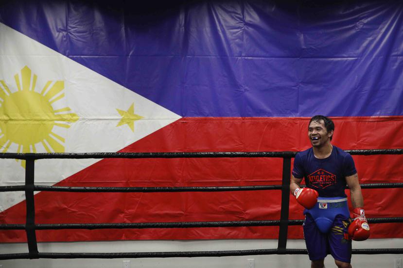 Frente a una bandera de Filipinas, el boxeador Manny Pacquiao sonríe durante un entrenamiento en el gimnasio Wild Card Boxing Club de Los Ángeles, el lunes 14 de enero de 2019. (AP)