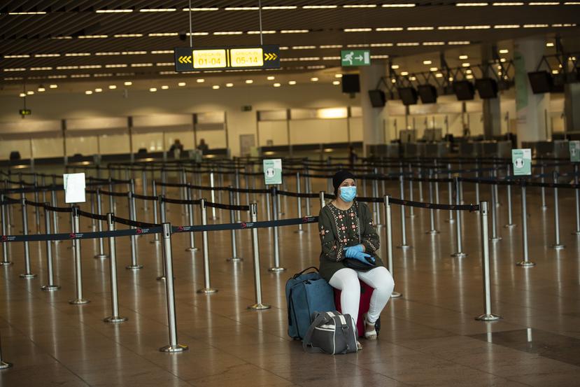 Una mujer solitaria espera frente al mostrador de una aerolínea en el aeropuerto Zaventem de Bruselas el 29 de julio del 2020.