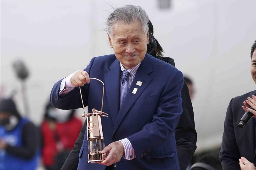 El jefe de los Juegos Olímpicos de Tokio 2020 Yoshiro Mori carga con la llama olímpica a su llegada a Japón. (AP)