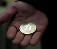 Un hombre sujeta un Bitcoin.