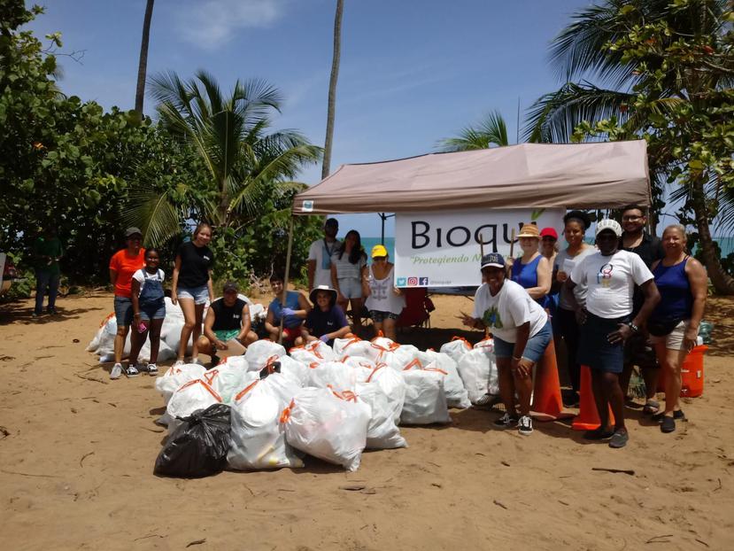 Los voluntarios posan con bolsas de basura durante la limpieza de la playa Vacía Talega de Loíza. (Suministrada)