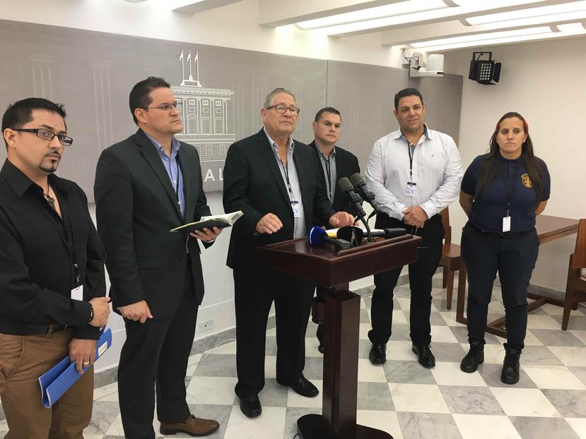 Al centro, José Tirado, presidente del Sindicato de Bomberos, durante una conferencia de prensa en La Fortaleza.