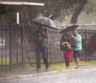 Foto de archivo que muestra a personas cubriéndose de la lluvia en la zona metropolitana.
