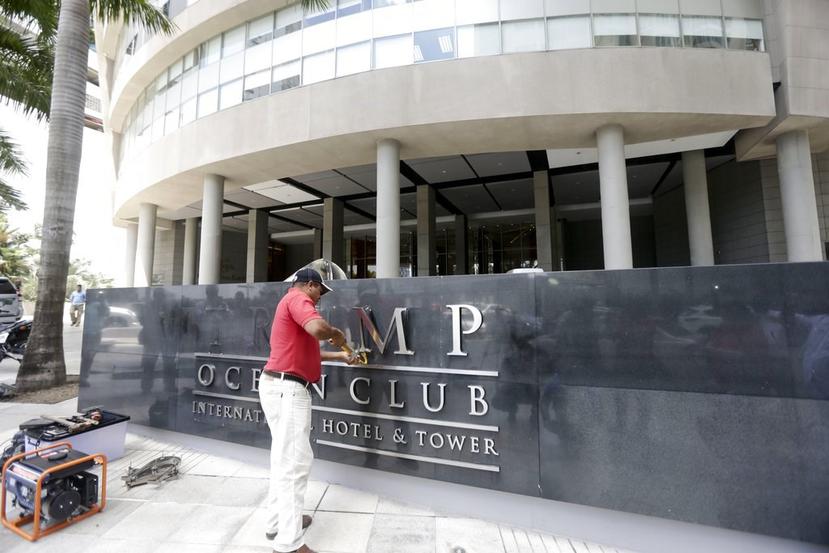 En esta foto de archivo del 5 de marzo de 2018 un hombre saca la palabra Trump del frente del Trump Ocean Club International Hotel and Tower en la ciudad de Panamá. (AP)