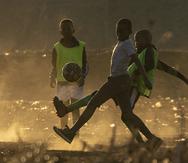 ARCHIVO - Foto del 23 de junio del 2021, niños juegan con un balón en un polvoso estadio en Duduza al este de Johannesburgo en Sudáfrica. El lunes 31 de octubre del 2022, relanzan el programa Fútbol para las Escuelas de la FIFA que busca que millones de niños de las regiones más pobres del mundo tengan acceso a este deporte en sus escuelas. (AP Foto/Themba Hadebe, Archivo)