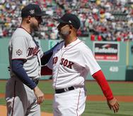 El dirigente puertorriqueño de los Red Sox Alex Cora saluda al manager de los Twins Rocco Baldelli previo al partido.