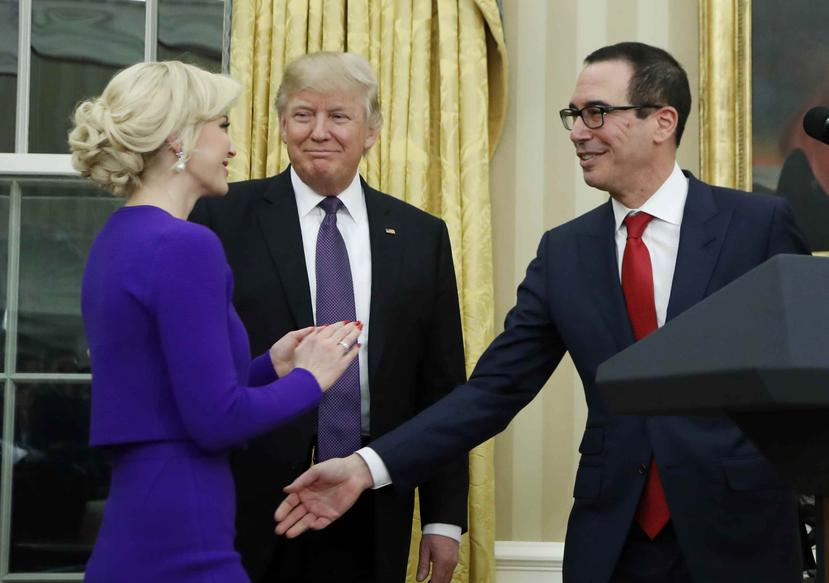 Donald Trump observa al secretario del Tesoro, Steven Mnuchin, mientras saluda a su ahora esposa, Louise Linton. (Archivo / AP)