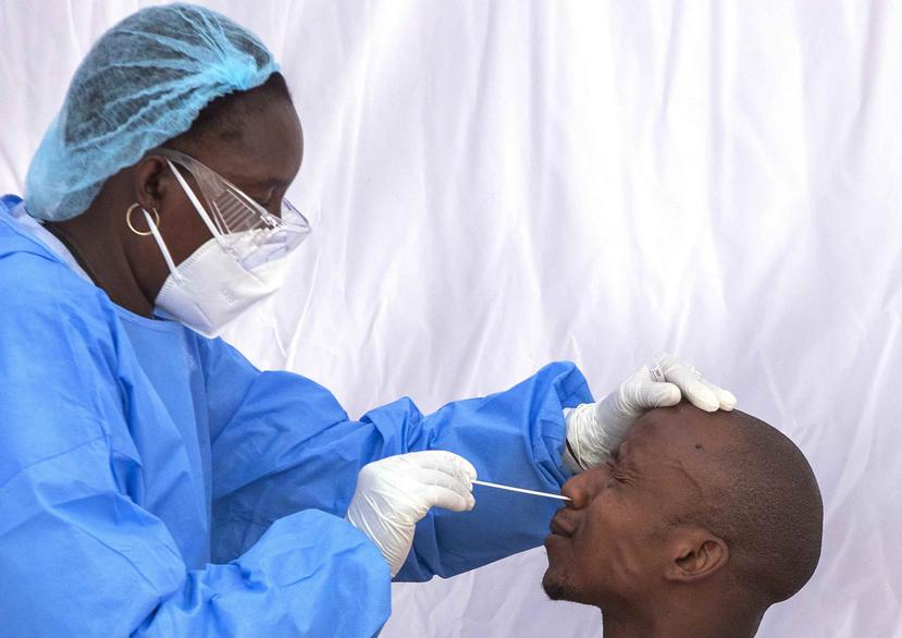 Un hombre reacciona mientras una sanitaria toma una muestra para una prueba de detección del coronavirus, en el vecindario de Tembisa, en Johannesburgo, Sudáfrica. (AP)
