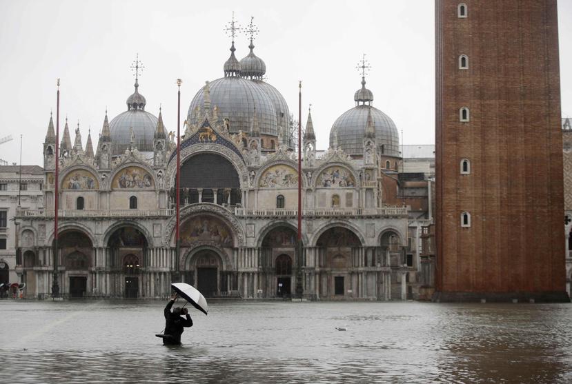 Un fotógrafo hace fotos en la inundada Plaza de San Marcos en Venecia. (AP)