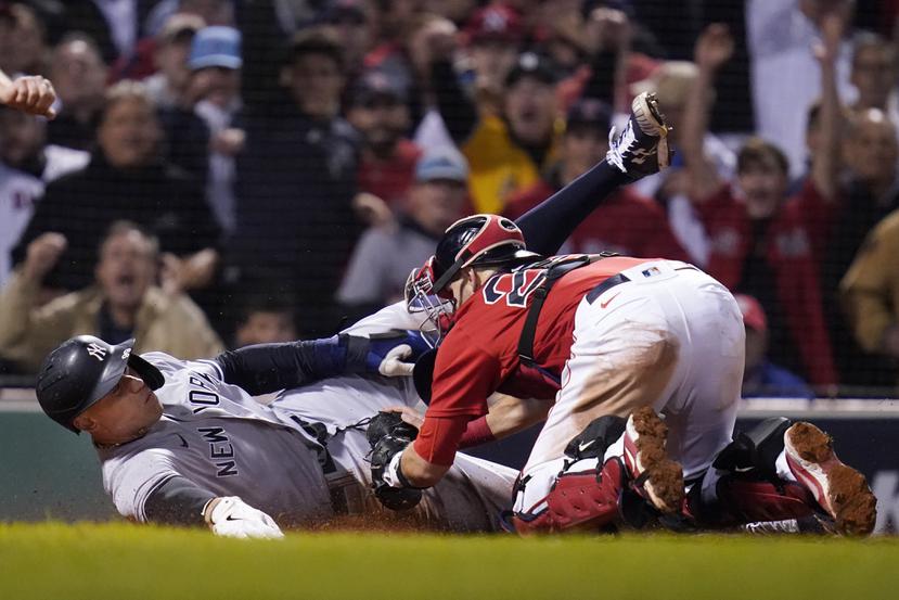 El receptor de los Red Sox Kevin Plawecki saca out a Aaron Judge, de los Yankees, en el plato en la sextra entrada.