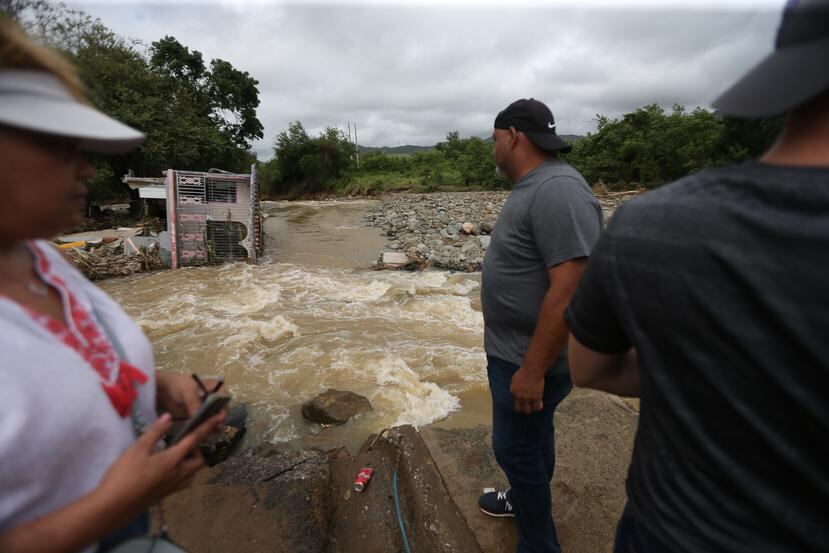 Residentes de la comunidad Guamaní, en Guayama, donde cinco casas y un carro fueron arrastradas por el río Guamaní.