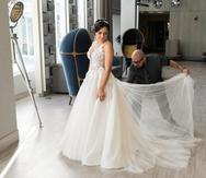 Jaer Cabán ajusta el vestido de novia confeccionado a Lillian Hernández. (Foto: Suministrada/Gabriel González)