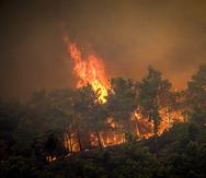 Las llamas se alzan de un incendio forestla en la islad de Rodas, Grecia, el sábado 22 de julio de 2023. (Argyris Mantikos/Eurokinissi via AP)