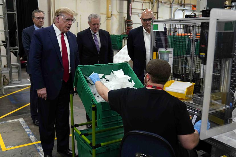 Donald Trump recorre la planta de Honeywell International que fabrica equipos protectores para personal médico el 5 de mayo de 2020 en Phoenix. El mandatario no usó unas mascarilla. Solo protector de ojos. (AP)