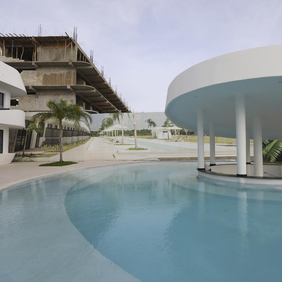 Área de la piscina del complejo Cana Rock Star, uno de los ocho proyectos disponibles en Cana Rock, Punta Cana. Al fondo, apartamentos en construcción.