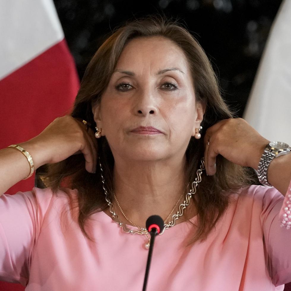 La presidenta de Perú, Dina Boluarte, muestra sus joyas durante una conferencia de prensa.