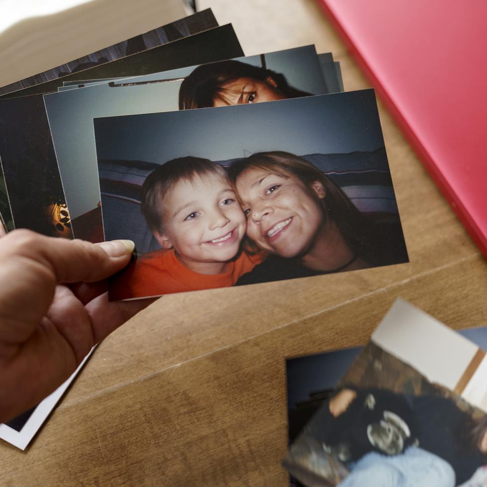 Rachel Taylor mira fotos de ella con su hijo Kyle Domrese, el 17 de noviembre de 2021, en su casa en Bemidji, Minnesota. Kyle Domrese fue uno de muchos indígenas norteamericanos que murieron por sobredosis en medio de la pandemia.