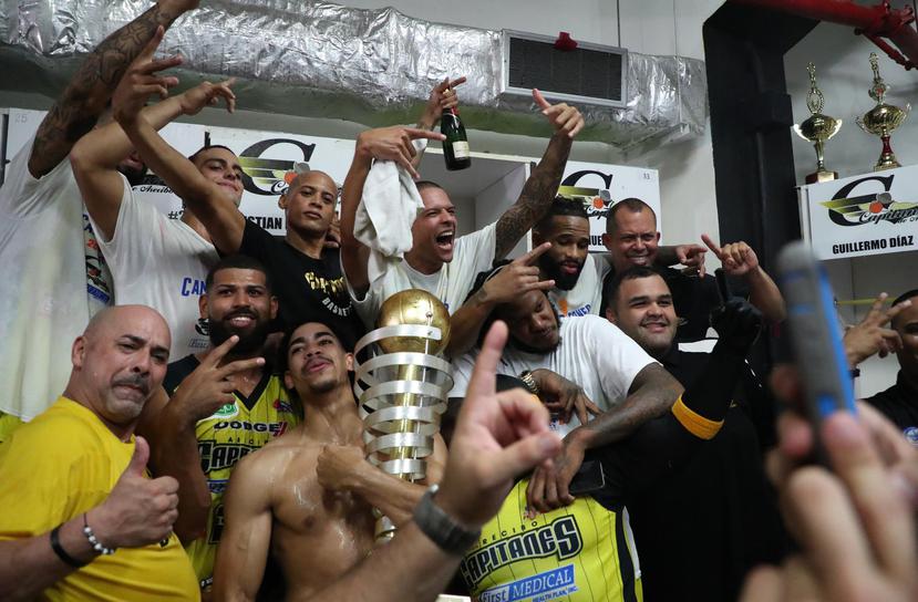 Los jugadores de Arecibo festejan en el camerino del coliseo Manuel “Petaca” Iguina  con el trofeo tras el partido del domingo.