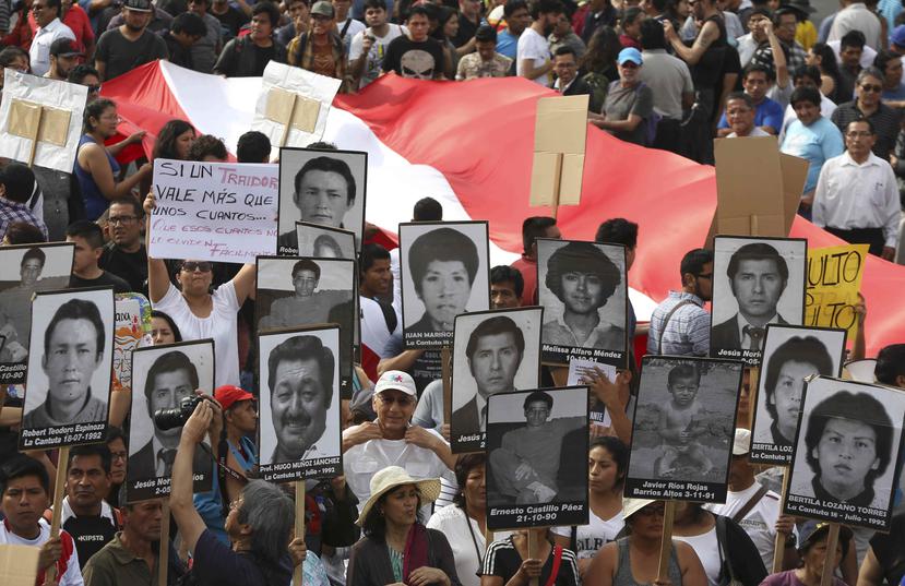 Manifestantes sujetan pancartas con fotos de los series queridos que desparecieron durante el tiempo en que el expresidente Alberto Fujimori estuvo en el poder en Perú. (AP / Martín Mejía)