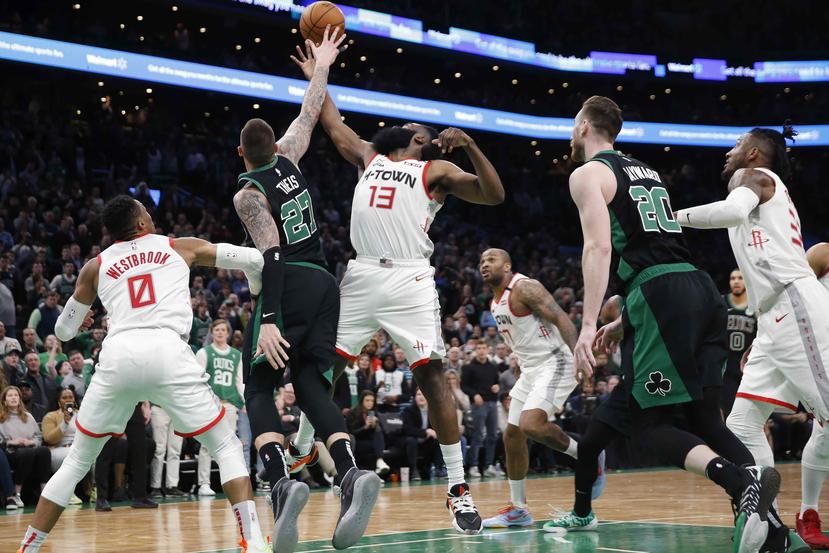 El jugador de los Celtics de Boston Daniel Theis (con el 27) y el jugador de los Rockets de Houston James Harden (13) luchan por el rebote tras una canasta fallida de Jaylen Brown, mientras se acaba el tiempo de la prórroga. (AP)