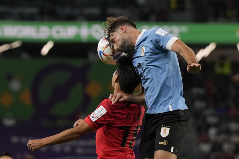 El uruguayo Matías Viña, a la derecha, y el coreano Lee Kang-in se enfrentan por el control del balón.