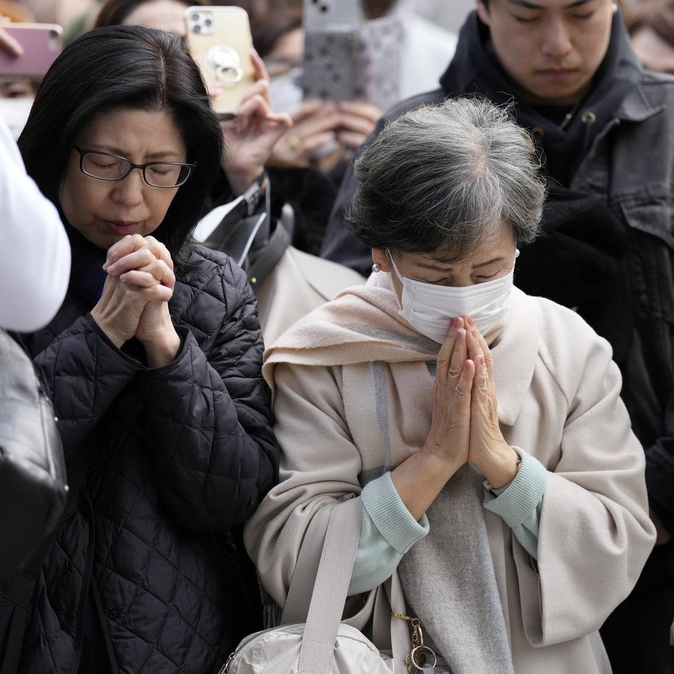 Personas orando en conmemoración de las víctimas del sismo y tsunami de hace 13 años en Japón, el 11 de marzo de 2024 en Tokio.