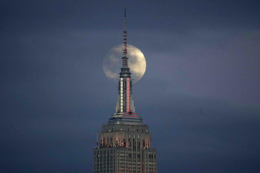 La Luna llena se alza por detrás del Empire State Building vista desde Jersey City, Nueva Jersey. (AP)