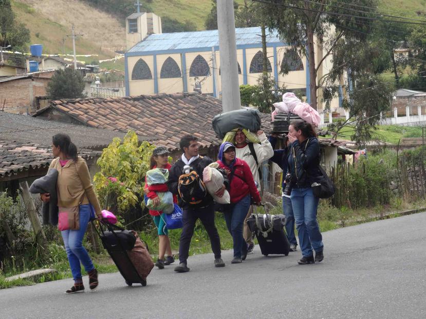 Inmigrantes venezolanos caminan por una carretera en Tulcán, Ecuador. (EFE)