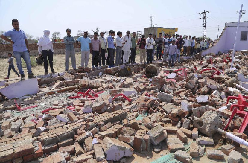 Unas personas observan los escombros dejados por el derrumbe de una enorme pared que cayó sobre los invitados de una boda en Bharatpur N.K. Gupta, en el oeste de India. (AP)