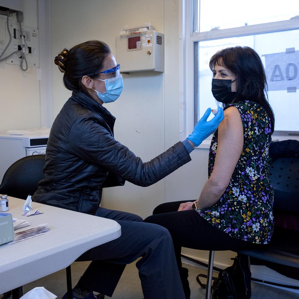 La enfermera Sarah Gonzalez le aplica a Claudia Zain su primera dosis de la vacuna contra el COVID-19 en una clínica de inoculación de New York Health and Hospitals en el distrito de Brooklyn, Nueva York.