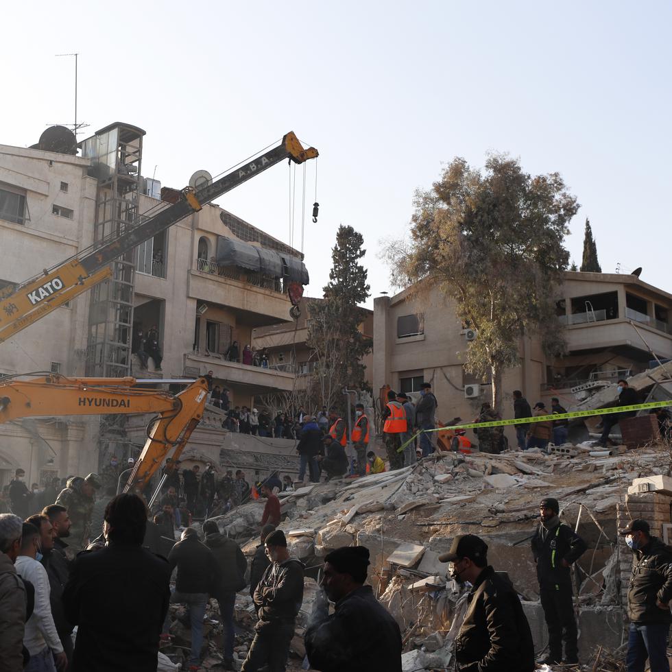 Personal del servicio de emergencias realiza tareas en un edificio impactado por un ataque aéreo israelí en Damasco, Siria.