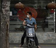 Un hombre porta una mascarilla frente a un restaurante de Beijing.