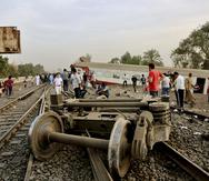 Unas personas observan los restos de un tren descarrilado cerca de Banha, en Egipto.
