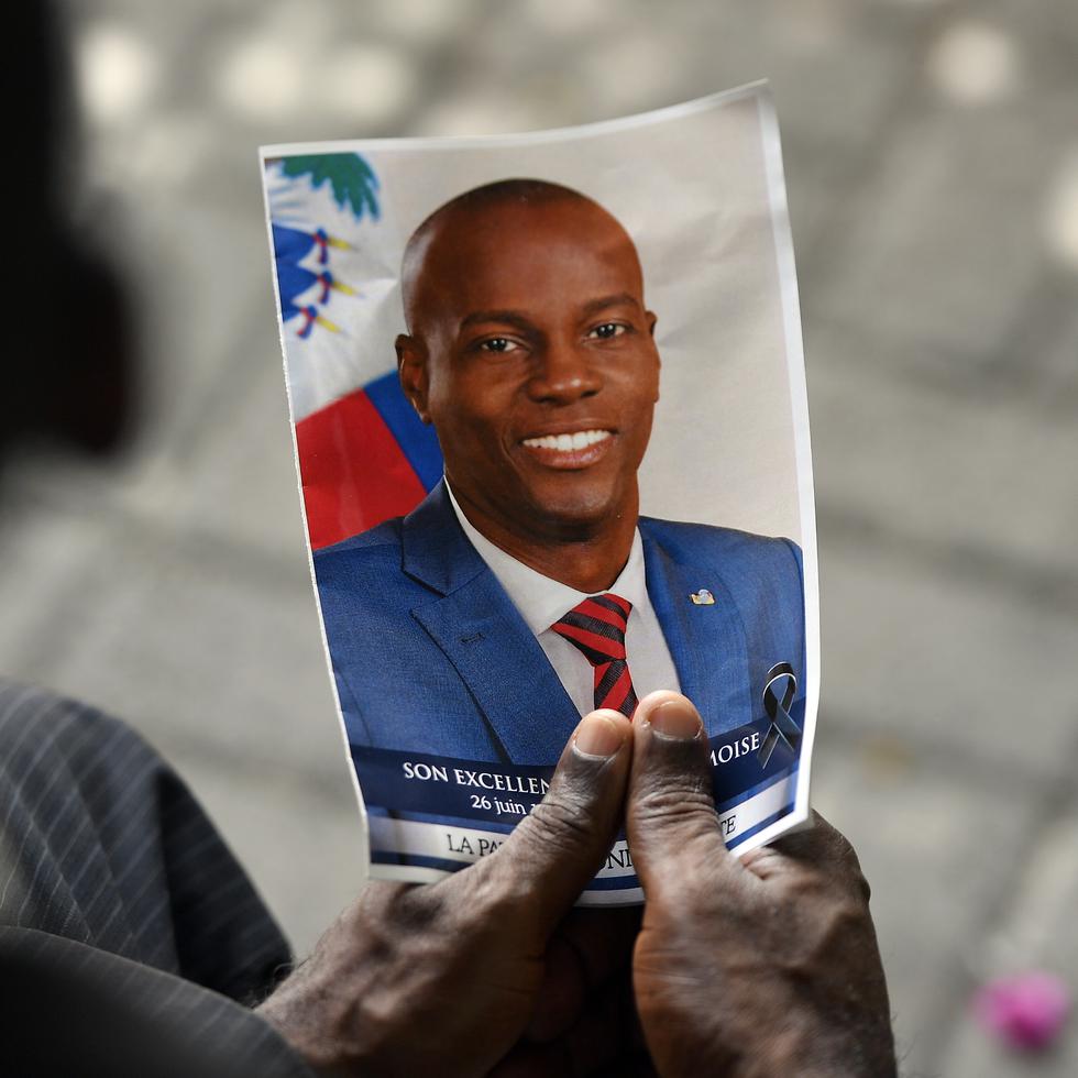 Una persona sostiene una fotografía del fallecido presidente haitiano Jovenel Möise durante una ceremonia conmemorativa en el Museo Nacional del Panteón en Puerto Príncipe, Haití.