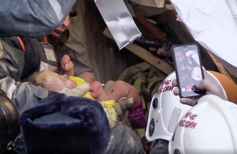 Imagen tomada de la televisión en la que se ve al infante en el momento que es rescatado. (AP)