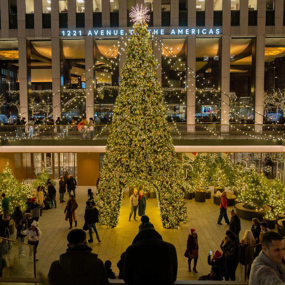 Personas se toman fotos en el árbol de navidad del edificio 1221 Avenue of the Americas en Manhattan, el15 diciembre de 2023, en Nueva York.
