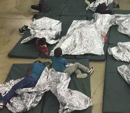 Menores detenidos por intentar entrar al país sin autorización descansan en una de las jaulas en el centro de McAllen, Texas. (AP)