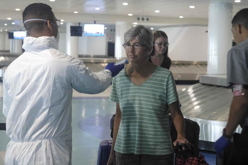 Efectivos de la Guardia Nacional continúan tomando la temperatura de los pasajeros que llegan a Puerto Rico como una medida para controlar los casos de coronavirus. (GFR Media / Gerald López Cepero)