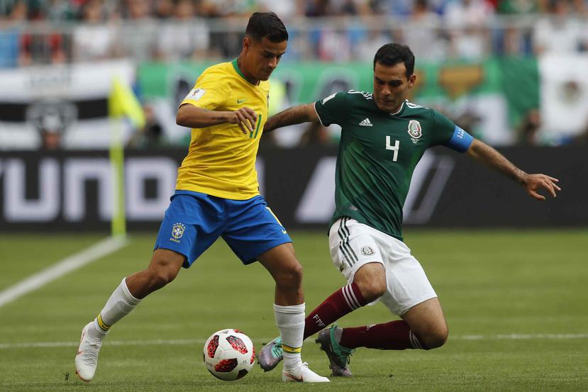 Rafael Márquez reta a Philippe Coutinho durante el partido entre México y Brasil. (AP)