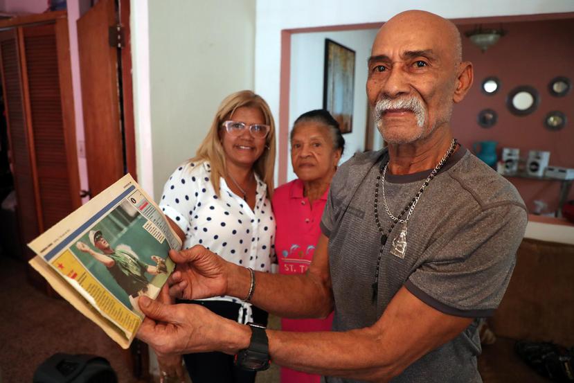 Ángel Luis “Güi” Báez muestra recortes de periódico de noticias de su nieto, Javier Báez. Atrás, Magda Báez —tía de Javier— y Margarita Matías, la abuela.