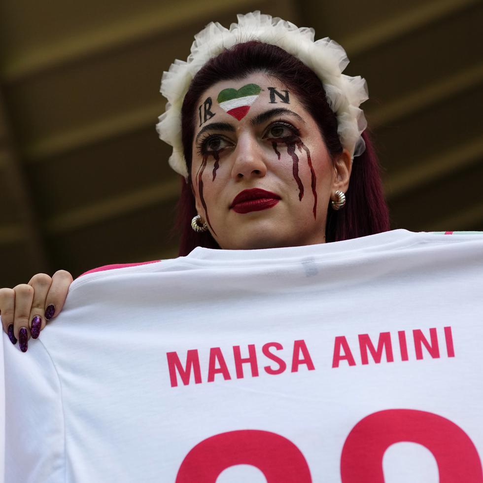 Una aficionada en la grada antes del partido del Grupo B del Mundial entre Gales e Irán, en el estadio Ahmad Bin, muestra una camiseta con el nombre de Mahsa Amini, una joven que murió tras ser detenida por la policía en Irán a los 22 años.