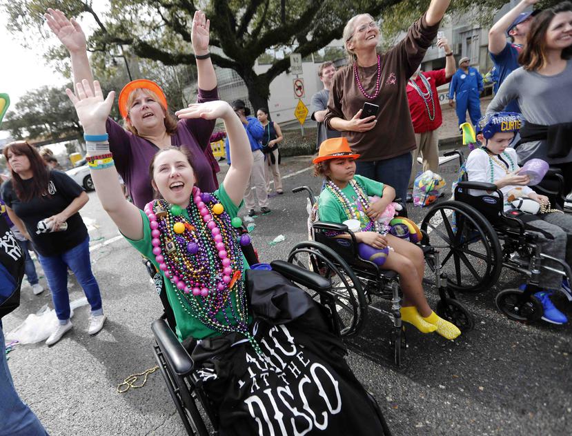 Pacientes del hospital infantil de Nueva Orleans saludan para recibir collares de cuentas en el exterior del centro durante el desfile de Krewe of Thoth del Mardi Gras, en Nueva Orleans. (AP)