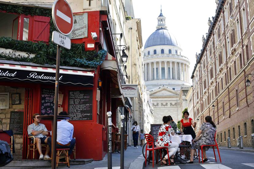 Un mesera atiende a clientas en una cafetería en París. (AP)