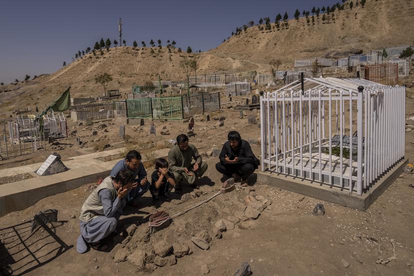 La familia Ahmadi reza junto a las tumbas de sus 10 familiares, incluidos siete niños, muertos por el ataque de un dron estadounidense, en Kabul, Afganistán.