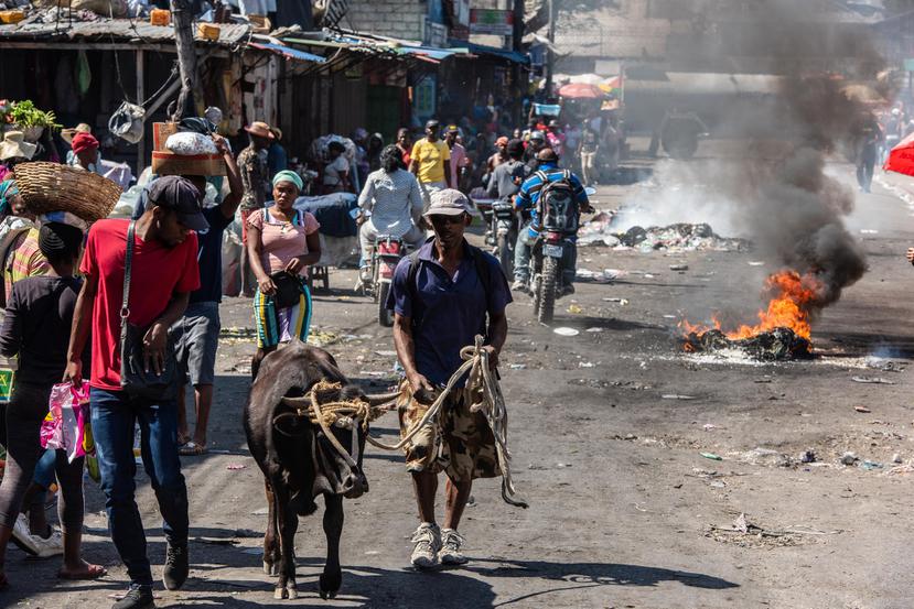 Vista de un mercado informal donde humean restos de neumáticos, debido a la protesta de los policías, en Puerto Príncipe, Haití. EFE/Johnson Sabin