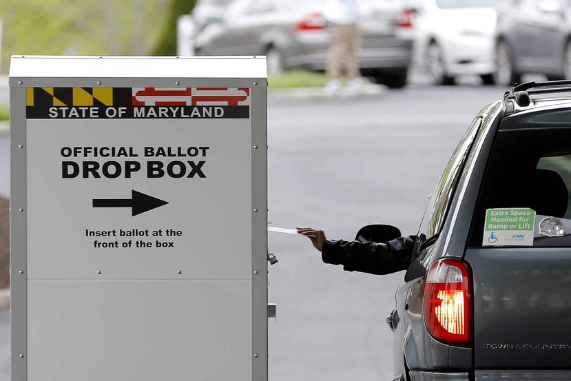 Un conductor deja una boleta por correo fuera de un centro de votación durante las elecciones especiales del Distrito 7 del Congreso.  (AP)
