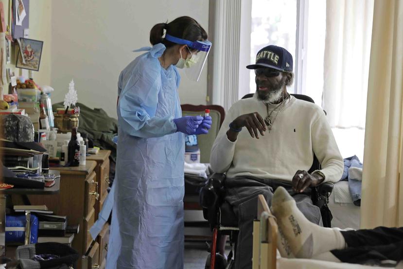 La doctora Gabrielle Beger preparándose para tomar una muestra nasal de Lawrence McGee como parte del equipo de médicos de la Universidad de Washington. (AP)