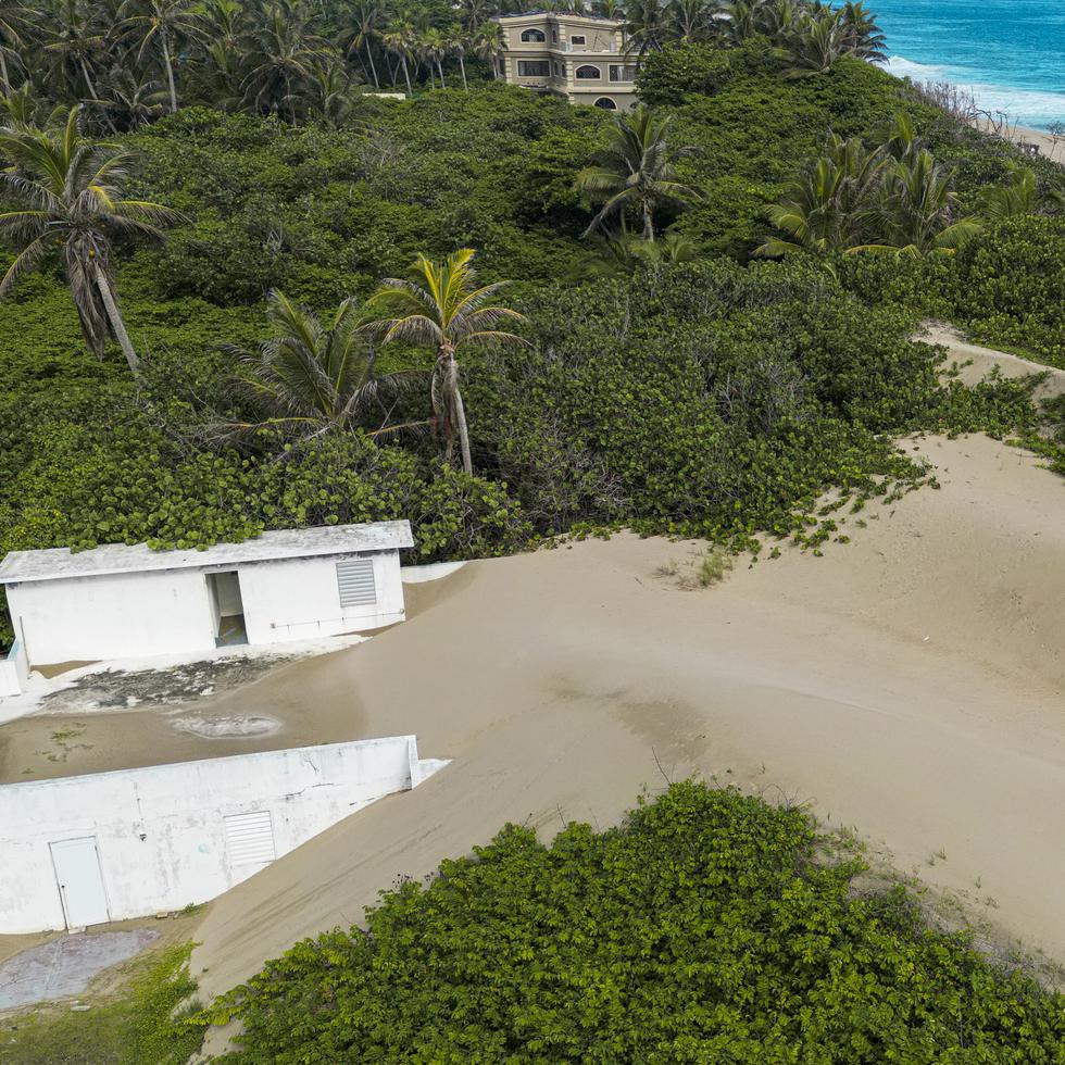 Fotografía aérea de impacto de la acumulación de arena sobre una residencia en la playa Hallows del barrio Islote en Arecibo.