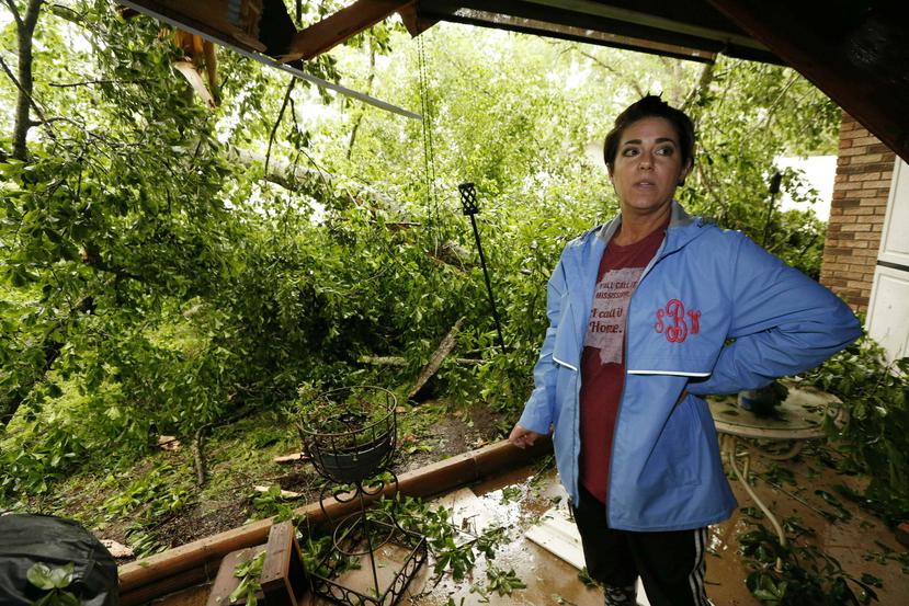 Sonya Banes habla con un periodista luego de que un roble cayó en el patio de la casa de su madre por los vientos fuertes en Learned, Mississippi. (AP/ Rogelio V. Solís)